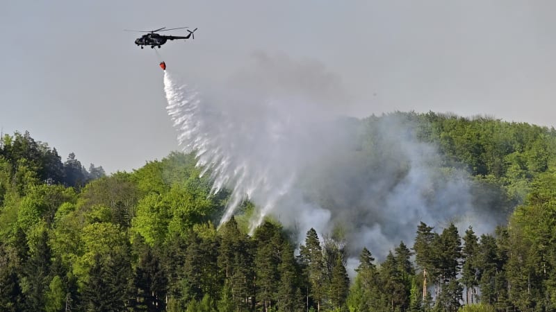 Osm vrtulníků včetně Black Hawků krotí požár Českého Švýcarska. Hasiči mají dobrou zprávu
